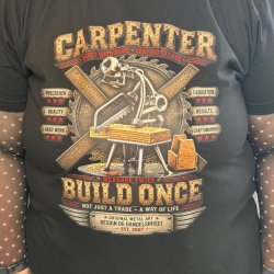 N�rbillede af t�mrertryk p� sort T-shirt med t�mrer metalfigur og v�rkt�j